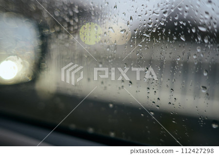 Window glass of a car wet with rain Rainy season image 112427298