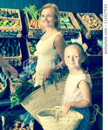 Mother and daughter choose vegetables in vegetable shop Mother and daughter choose vegetables in vegetable shop 112427910