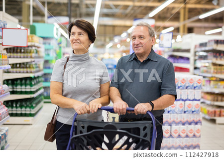 Married couple choose groceries together in supermarket Married couple choose groceries together in supermarket 112427918