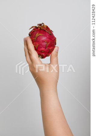 Fresh pitahaya in female hand on white background. Dragon fruit. Fresh pitahaya in female hand on white background. Dragon fruit. 112428429