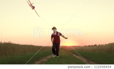 child kid boy Flying kite Bright sunset, children running flying kite Evening sky park sunset, boy running happily playing along country road, Running boy, kid child son schoolboy running, wind flying 112430454