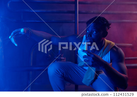 Young cool guy rapper posing for camera in neon light Young cool guy rapper posing for camera in neon light 112431529
