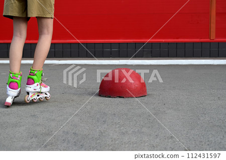 Full-length portrait of a smiling girl with long hair on roller skates 112431597