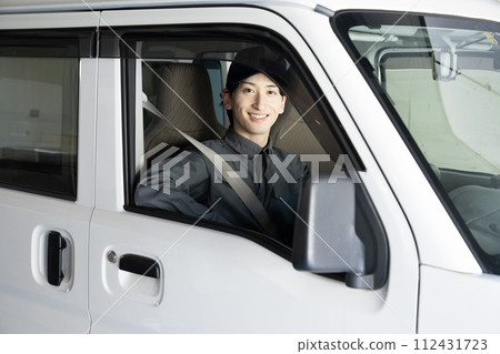 A man working in the waste collection business who rides a light car 112431723