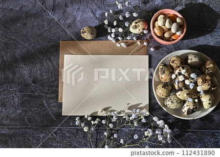 Create an Easter composition of Easter quail eggs and flowers on a white wooden background. A greeting card for the Easter holiday.Top view, copy location, flat layout. Create an Easter composition of Easter quail eggs and flowers on a white wooden background. A greeting card for the Easter holiday.Top view, copy location, flat layout. 112431890