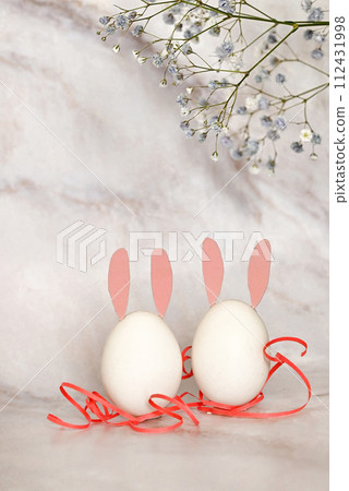Easter composition of eggs and flowers on a light background. Easter bunny. A gentle greeting card for the Easter holiday.Top view, copy location, flat layout. 112431998