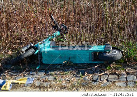 Electric scooter abandoned. Ein im Gras liegender Elektroroller. Electric scooter abandoned. Ein im Gras liegender Elektroroller. 112432551