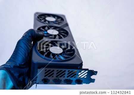 hand of a computer technician holds a modern powerful video game card hand of a computer technician holds a modern powerful video game card 112432841