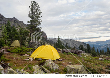 landscape with two tents on forest hill among rocks 112432933