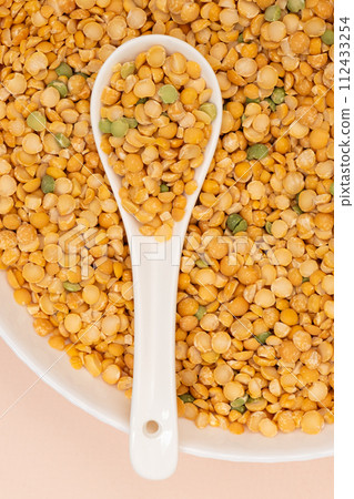 Pea yellow groats grains cereal in spoon close-up macro. Pea yellow groats grains cereal in spoon close-up macro. 112433254