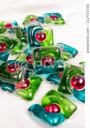 Lots of laundry pods on satin fabric close-up. 112433338
