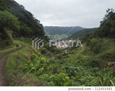 Aerial view on Machico town from Levada do Canical hiking trail. Footpath in green hills and tropical vegetation on Madeira island, Portugal, Europe. 112433381