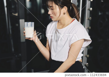Woman drinking protein at training gym 112433694