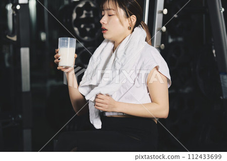 Woman drinking protein at training gym 112433699