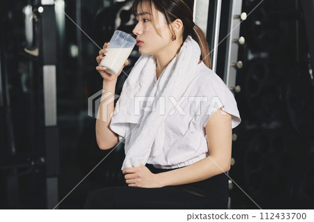 Woman drinking protein at training gym 112433700