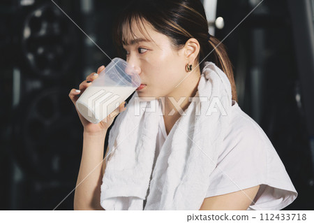 女人在健身房訓練時喝蛋白質 女人在健身房訓練時喝蛋白質 112433718