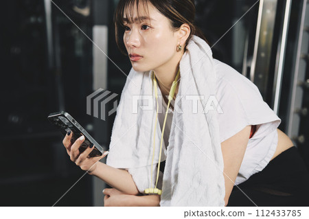 Woman using smartphone at training gym 112433785