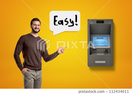 Man pointing to an ATM machine saying 'Easy' Man pointing to an ATM machine saying 'Easy' 112434011