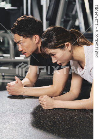 Young male personal trainer with a serious expression at the training gym 112434083