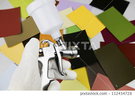 paint spray gun at work at the workplace in the workshop. 112434728