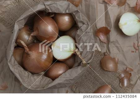 Onions in a paper eco-friendly craft bag package, storage, purchase. A picture for your text or advertisement. Onions in a paper eco-friendly craft bag package, storage, purchase. A picture for your text or advertisement. 112435084
