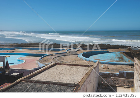 Abandoned swimming pool on the rooftop in Casablanca city, Atlantic beach on the background 112435353