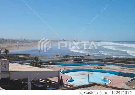 Abandoned swimming pool on the rooftop in Casablanca city, Atlantic beach on the background 112435354