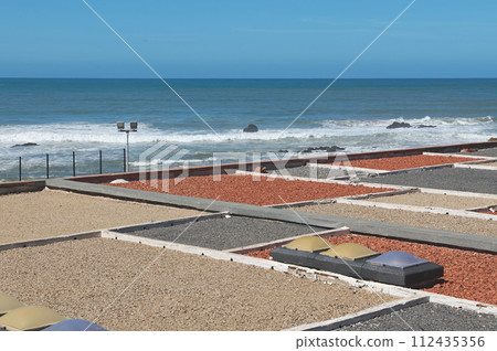 View from above of rooftop decorated with colorful stones. Atlantic ocean on the background 112435356