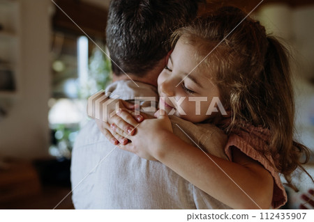 Daughter hugging father lovingly, closed eyes. Unconditional paternal love, Father's Day concept. Daughter hugging father lovingly, closed eyes. Unconditional paternal love, Father's Day concept. 112435907