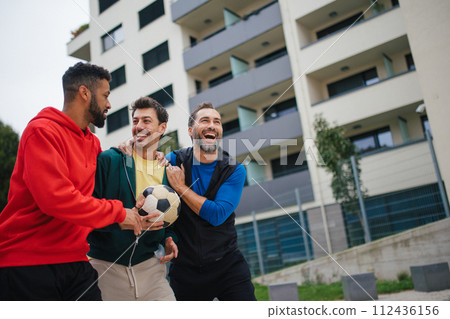 Best friends playing sport outdoors, having fun, competing. Playing football at local field, enjoying exercise together. Concept of male friendship, bromance. Best friends playing sport outdoors, having fun, competing. Playing football at local field, enjoying exercise together. Concept of male friendship, bromance. 112436156