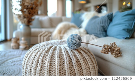 AI-generated content. A knitted beanie laying on top of a white couch in an interior setting. 112436869