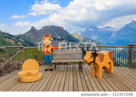 Wooden statues of cows with bench on observation deck at Schynige Platte, Switzerland 112437299
