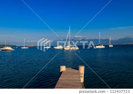 Wooden pier overlooking the Alps and Lake Geneva in Switzerland 112437723