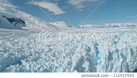 Aerial slow motion calving glacier of snow Antarctica continent. Climate change with global warming at ice land. Nobody nature landscape of arctic winter. Environment preserve concept at panorama shot 112437950