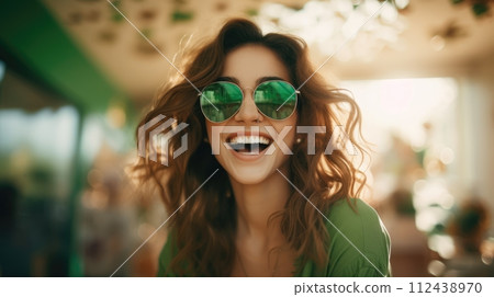 AI-generated content. Happy woman with brown hair in sunglasses smiling at camera. Isolated on blurred background. St Patricks Day 112438970