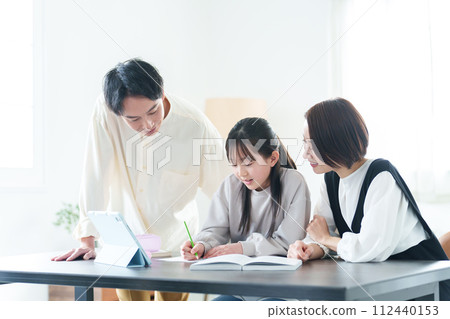 Girl studying, parents teaching Girl studying, parents teaching 112440153
