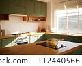 a sun-filled green kitchen 112440566