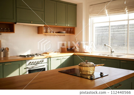 a sun-filled green kitchen 112440566