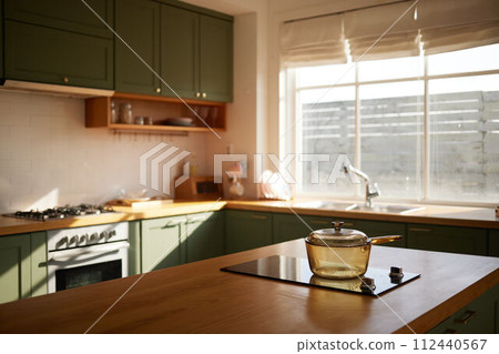a sun-filled green kitchen 112440567