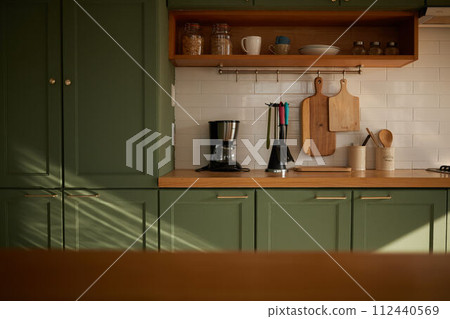 a sun-filled green kitchen 112440569