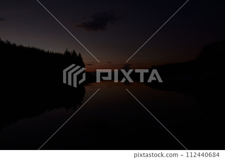 The surface of the water reflects the dawning sky. Venus rising above the forest, Fuji covered by Kasa clouds 112440684
