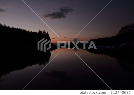 The surface of the water reflects the dawning sky. Venus rising above the forest, Fuji covered by Kasa clouds 112440685