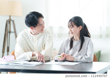 Tutor teaching girl studies Tutor teaching girl studies 112440707