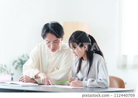 Tutor teaching girl studies Tutor teaching girl studies 112440709