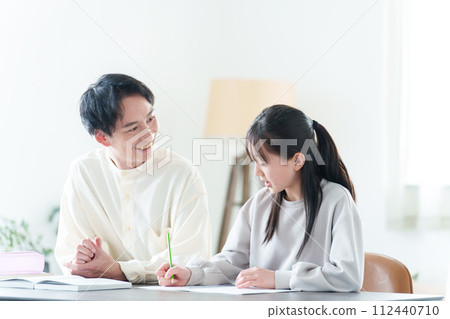 Tutor teaching girl studies 112440710