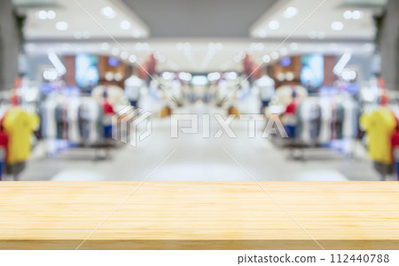 Empty wood table top with blur clothing boutique display interior shopping mall background Empty wood table top with blur clothing boutique display interior shopping mall background 112440788