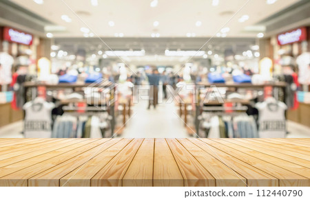 Empty wood table top with blur clothing boutique display interior shopping mall background 112440790