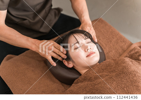 A woman and a chiropractor/therapist performing head massage, head spa, scalp massage, scalp care, and small face correction A woman and a chiropractor/therapist performing head massage, head spa, scalp massage, scalp care, and small face correction 112441436