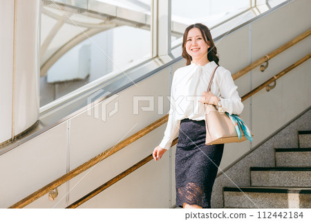 上班、工作、轉機、出差（步行）途中在車站樓梯上行走的女商人 112442184