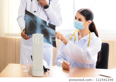 Doctor Team examining and checking at chest and lung x ray film of patient at hospital room.  112442299
